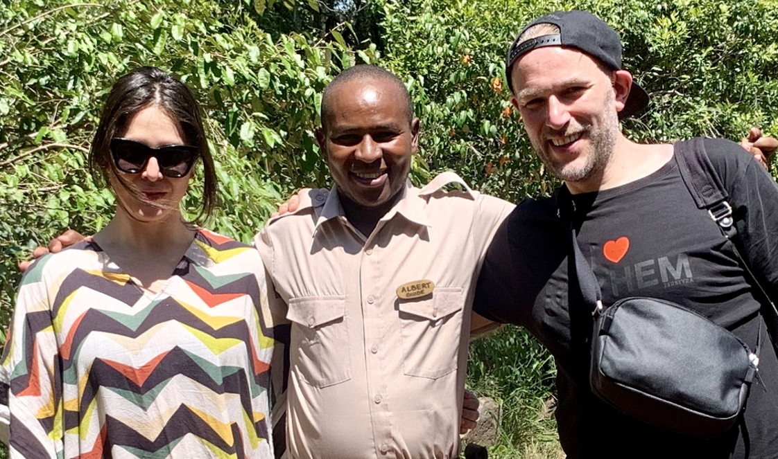 Guests stand on either side of a guide, their arms draped around one another.