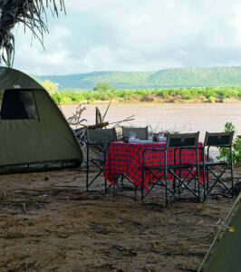 Adventure camping setup by a river in Tsavo East.