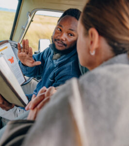 Guide explaining to guest from a book.
