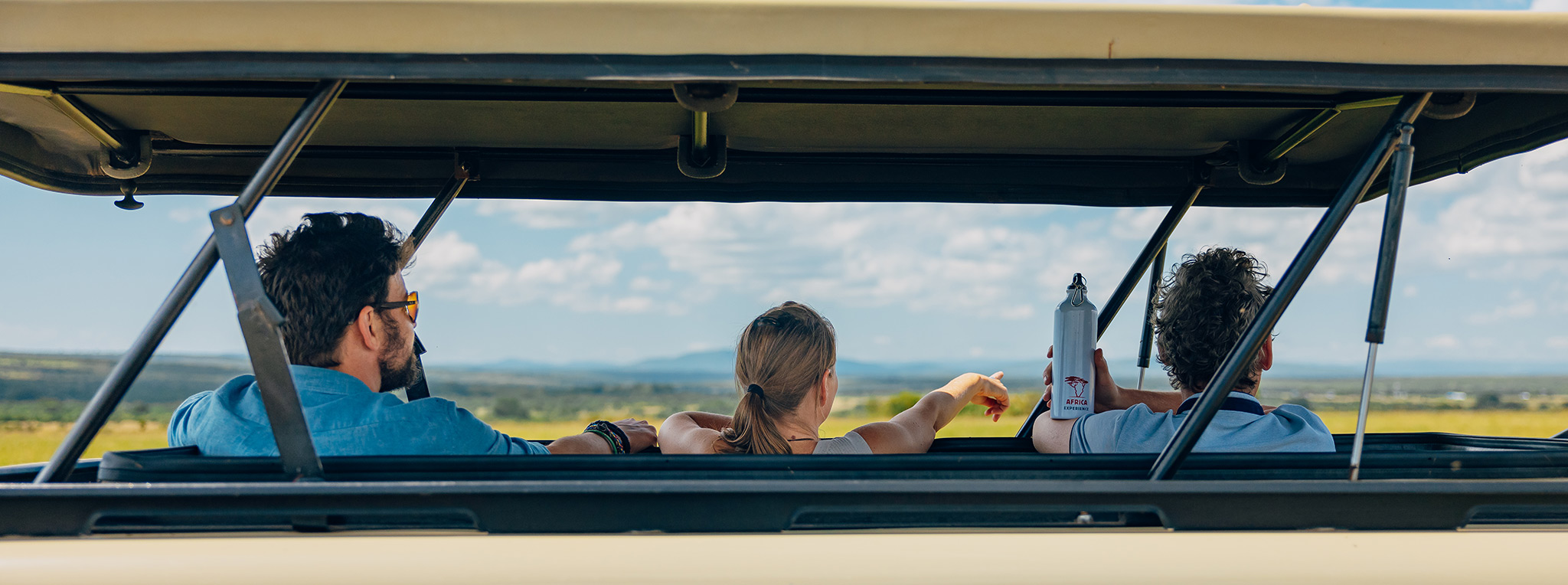 A group of travellers looking out of the pop-up roof while on safari in Kenya.