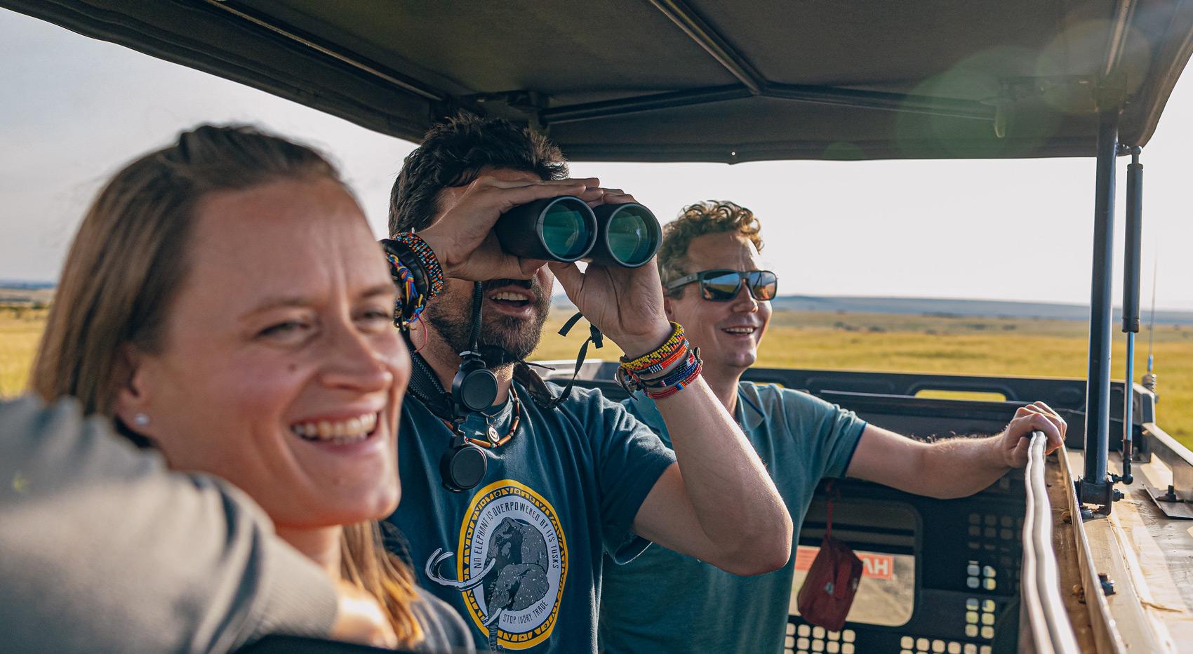 Guests looking at wildlife through a popup roof in a safari vehicle.