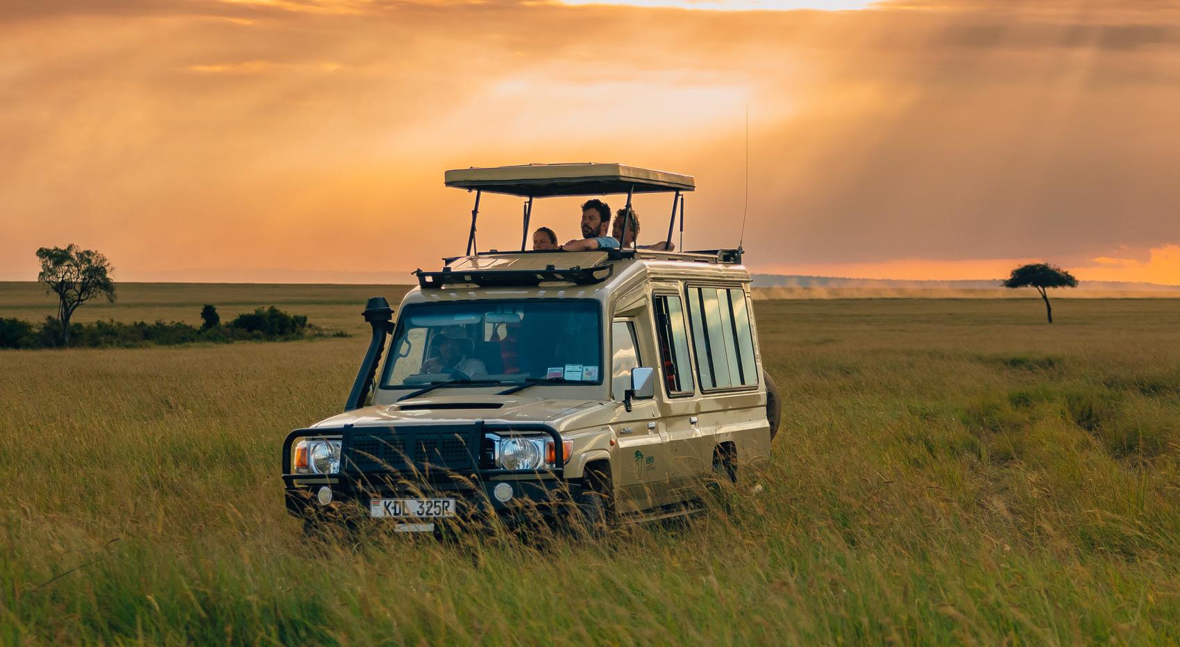 Guests looking out of the pop roof of a game drive vehicle on the best safari in Kenya. Guests looking out of the pop roof of a game drive vehicle on the best safari in Kenya.