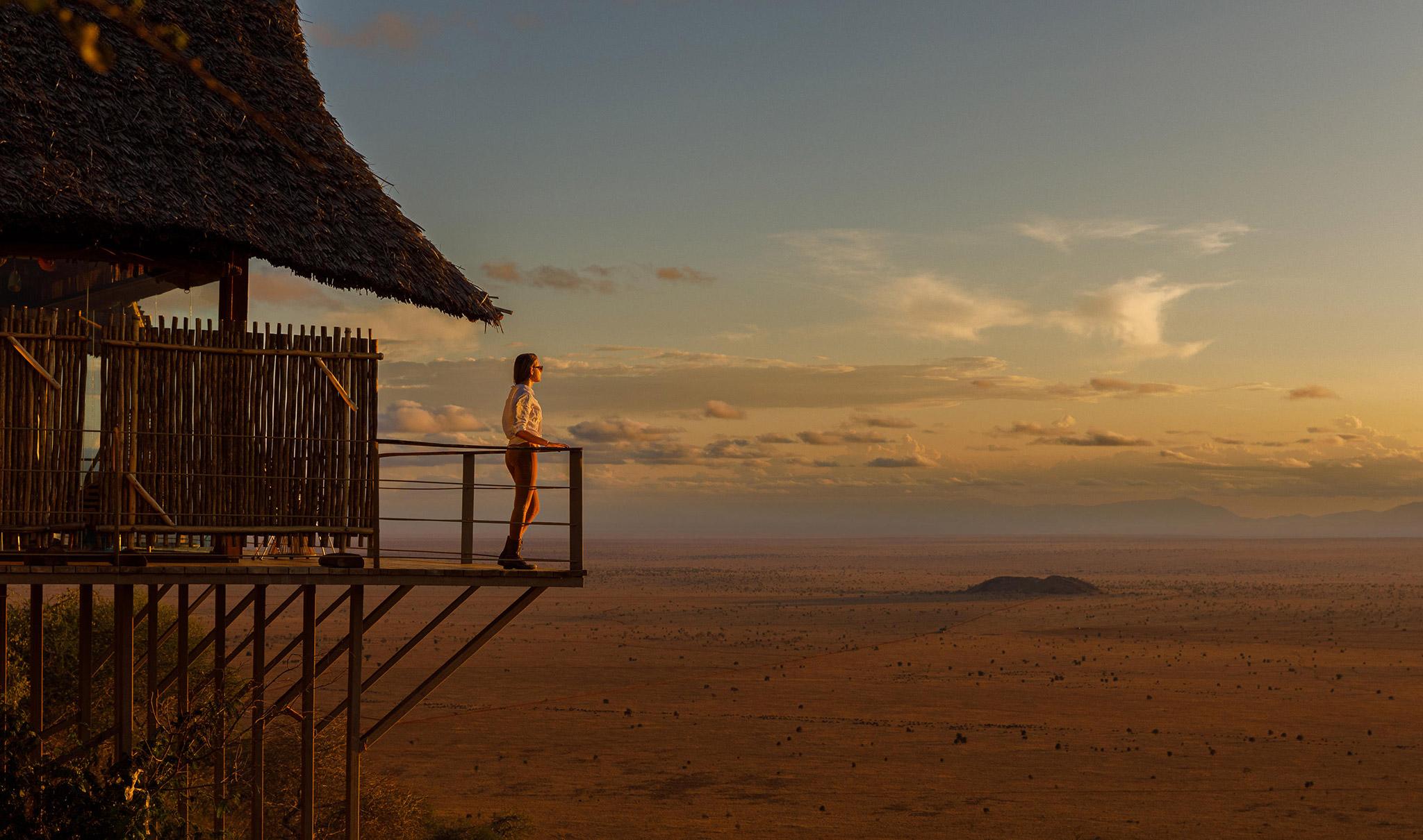 A woman overlooking Lumo Conservancy from Soroi Lions Bluff lodge in Kenya.